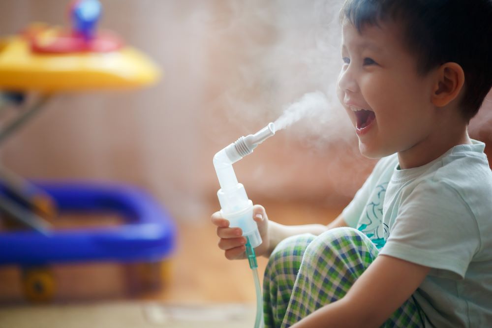 Young boy receiving breathing treatments through a nebulizer machine