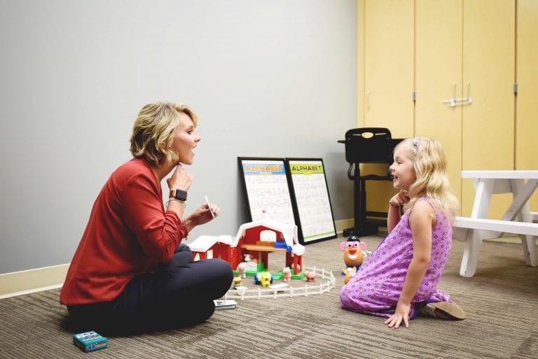 speech therapist in a session with a little girl while using flashcards