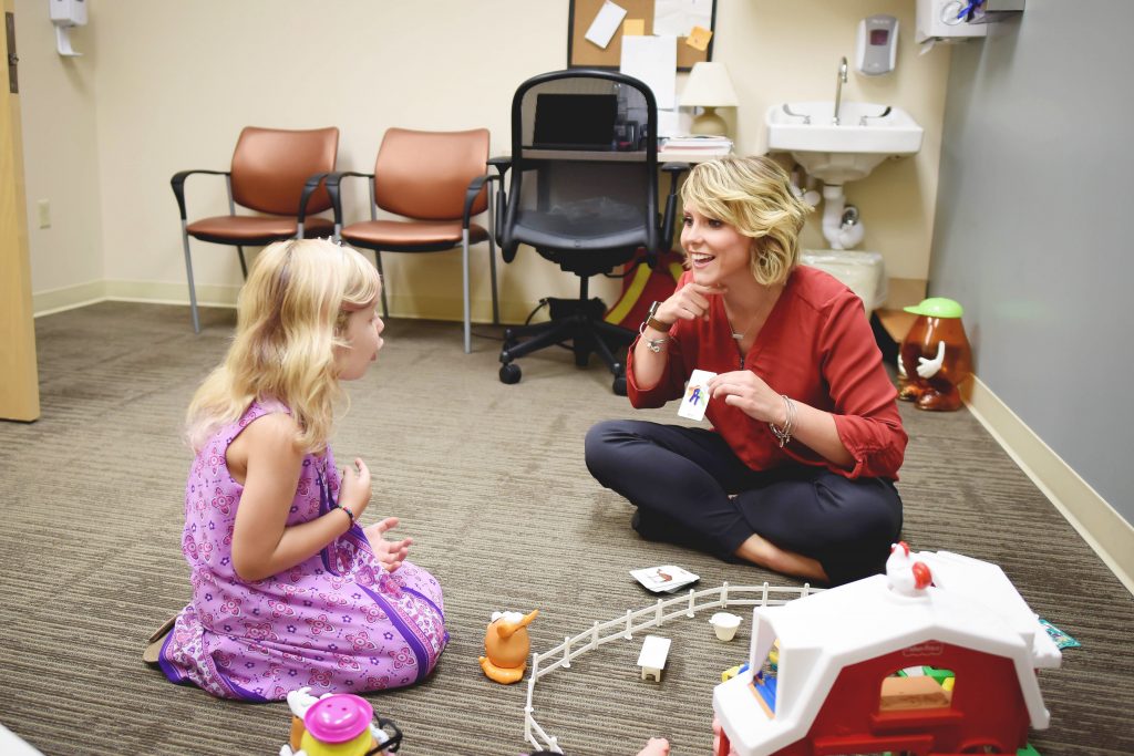 speech therapist in a session with a little girl